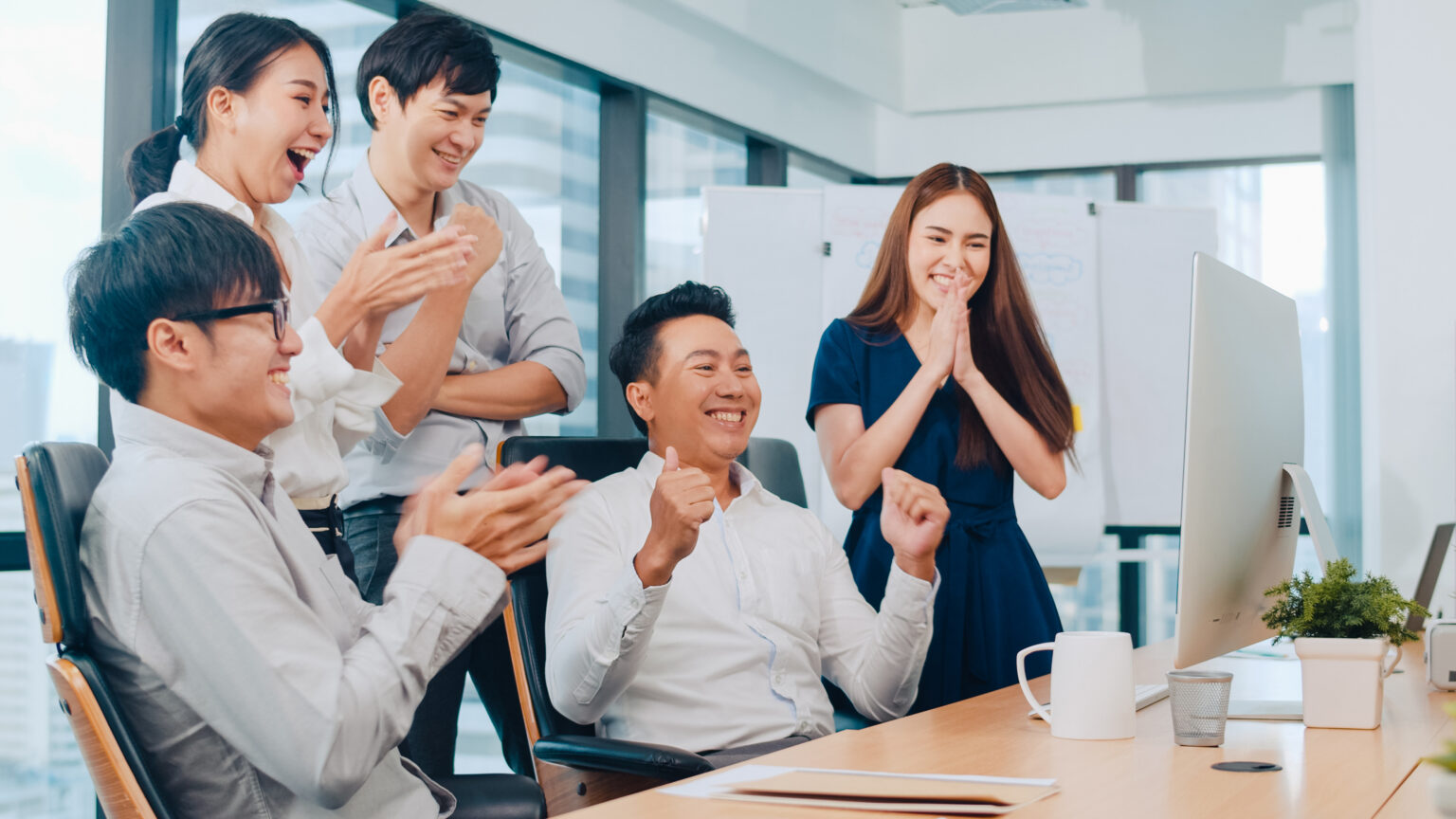 millennial group young businesspeople asia businessman businesswoman celebrate giving five after dealing feeling happy signing contract agreement meeting room small modern office scaled